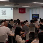 国際イベント会場でQRコードを読み込む参加者たちの様子